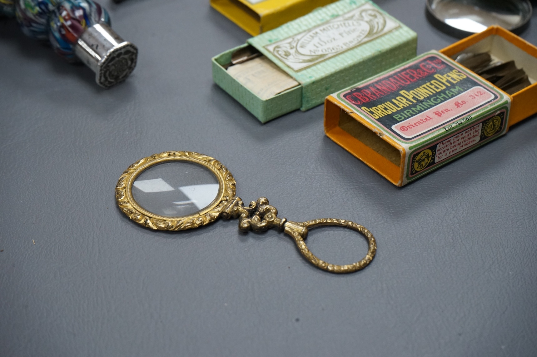A small collection of objects to include a 17th century? French multi-cane glass seal, miniature white metal mirror and boxed pen nibs, seal 8cm high
